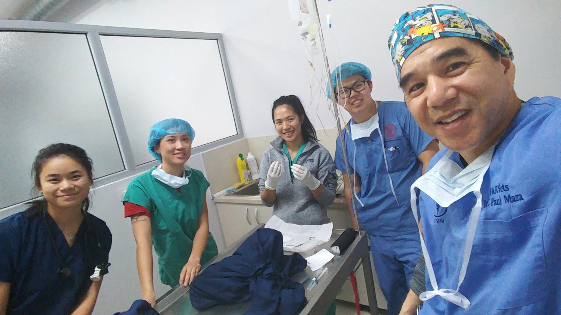 Four FARVets veterinary professionals gathered around a surgical table in a clean clinic