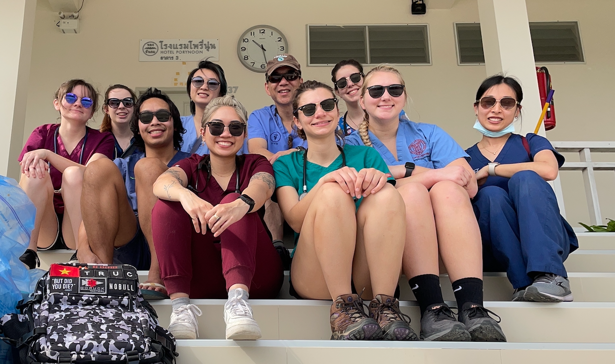 FARVets team seated together on the steps of their base hotel between clinic days